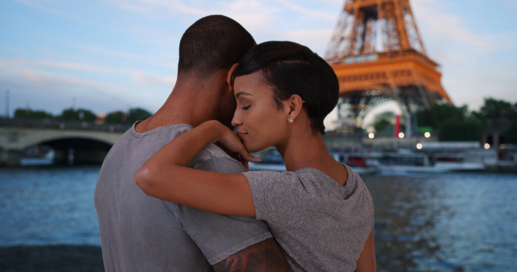 Traveling couple enjoying a view of Eiffel Tower by the River Seine.