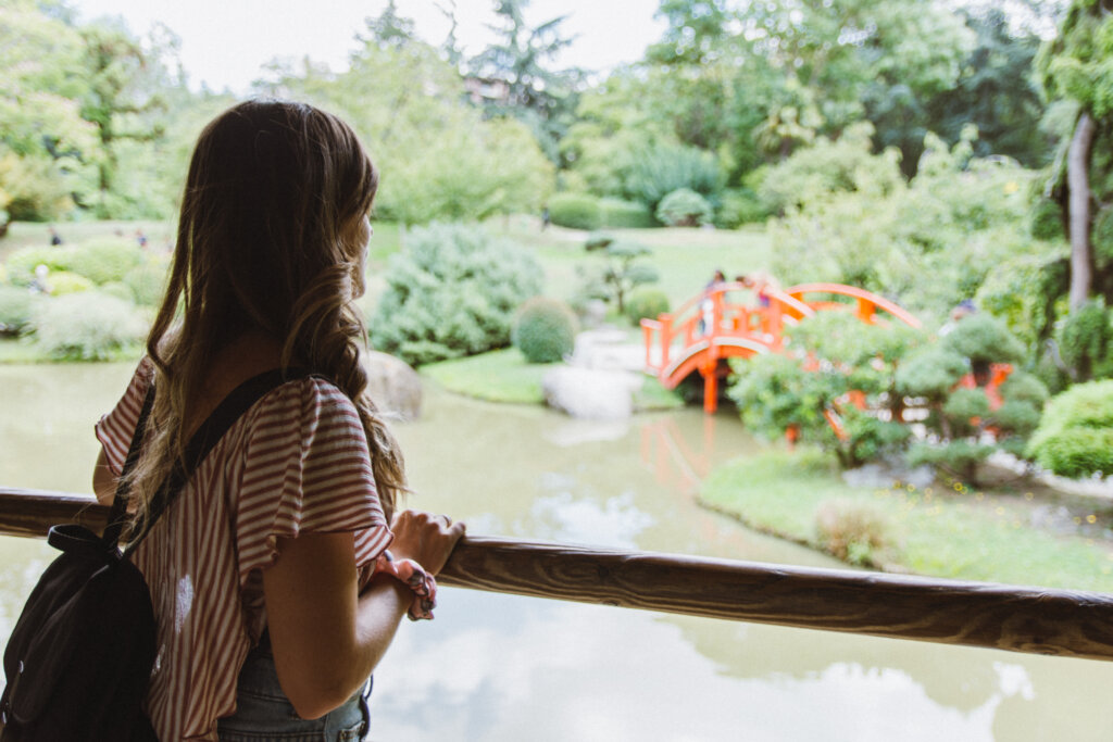 Girl alone looking from a wooden terrace to a Japanese garden in downtown Toulouse, France