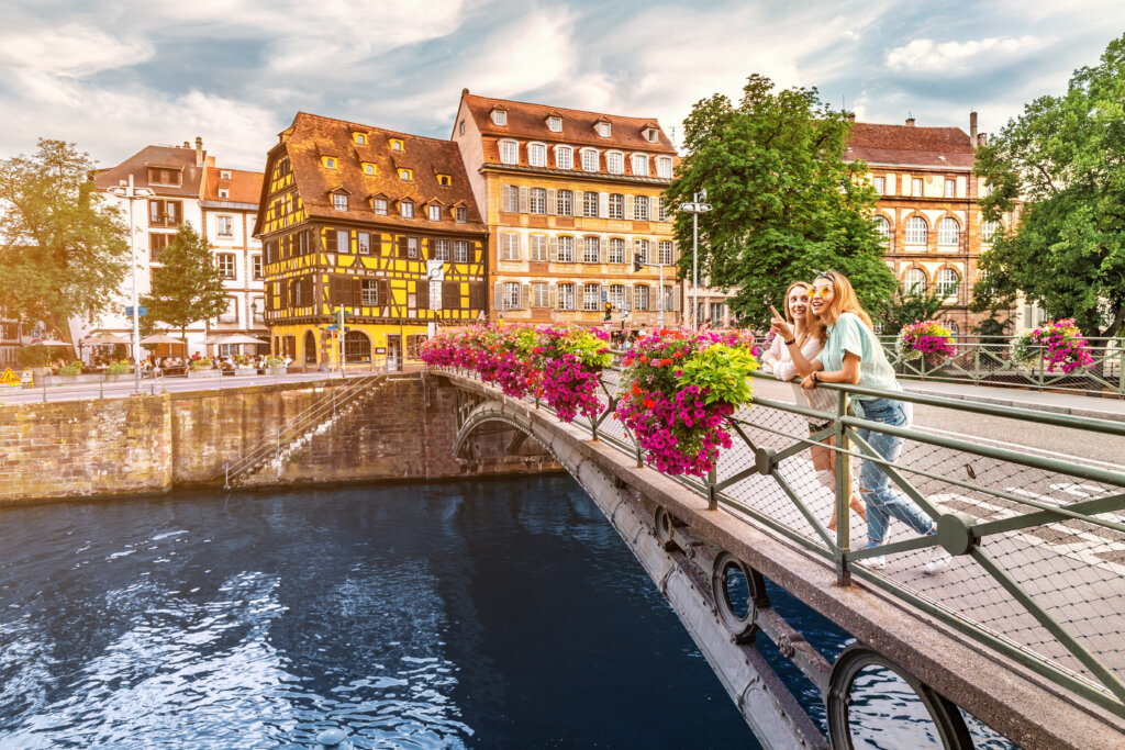 Two happy young women standing on a bridge in Strasbourg, France.